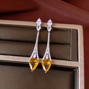 Detail shot of vintage 18k gold plated drop earrings featuring yellow pear zircons