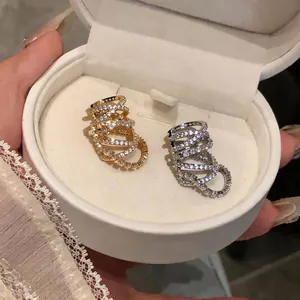 Macro shot of gold and silver multi-layer cubic zirconia ear cuffs in a white velvet box
