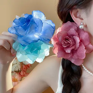 Nahaufnahme von eleganten Mesh-Blumen-Haarspangen in kräftigem Blau und zartem Rosa