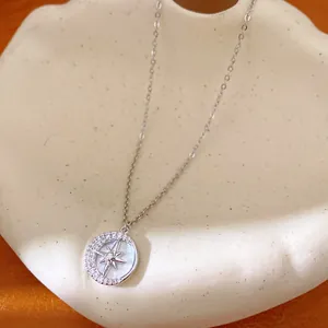 Primo piano di una collana circolare minimalista con un elegante motivo di luna e stelle