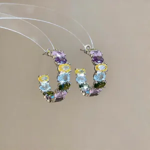 Detailed view of elegant C-shaped hoop earrings featuring colorful oval-cut cubic zirconia
