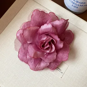 Nahaufnahme einer eleganten malvenfarbenen Netz-Blumen-Haarspange mit zarten Stoffblüten