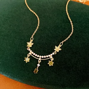 18k gold plated necklace with green zircon flowers and teardrop pendant on velvet