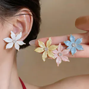 Detailed close-up showing vibrant pastel flower stud earrings with zircon centers on a model