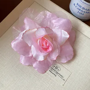 Nahaufnahme einer ätherischen rosa Haarspange aus Stoff und Mesh-Rose für Damen