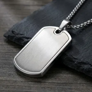 Detail of a stainless steel dog tag pendant featuring a sleek brushed metal finish.