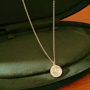 Primo piano di una collana con ciondolo a stella placcata oro 14k su velluto verde