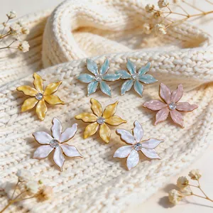 Detail showing colorful enamel flower earrings with zircon center on knit background