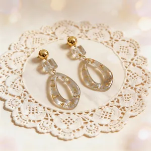 Detailed close-up showing the intricate gold foil embedded in clear resin drop earrings