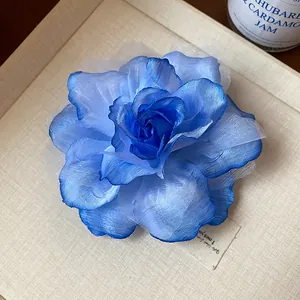 Detailansicht eines eleganten Haarclips aus blauem Netzstoff mit feinen Blüten