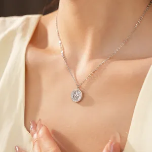 Primo piano di una delicata collana con pendente circolare, motivo a stella e zirconi