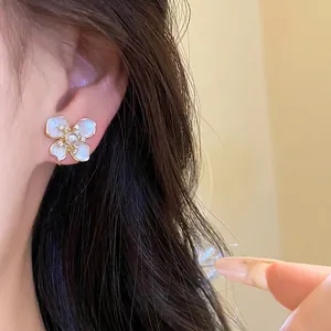 Elegant white pearl flower stud earrings with sparkling zircon accents on ear