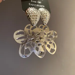 Nahaufnahme der Vintage-Ohrhänger mit hohlem Blumenmuster und strukturierter Oberfläche.