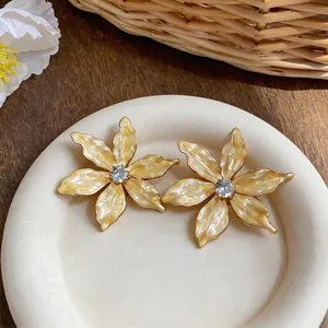 Close-up of elegant flower stud earrings with cream marbled petals and center zircon
