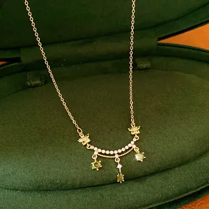 Close-up view of 18k gold plated necklace with green zircon flower and teardrop pendants