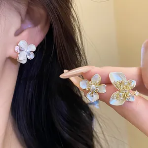 Detailed macro view of elegant white flower earrings with pearls and shimmering zircons