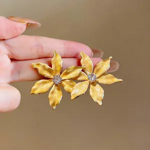 Detail view of sweet style 18k gold plated yellow enamel flower stud earrings with zircon