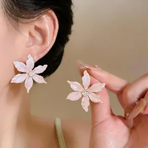 Close-up detail of elegant 18k gold plated pink flower stud earrings with zircon center