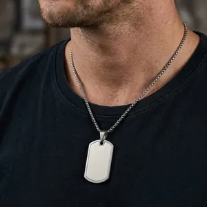 Detail of a brushed stainless steel dog tag pendant necklace on a male model.