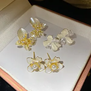 Detail of white pearl and zircon flower stud earrings displayed in a gift box