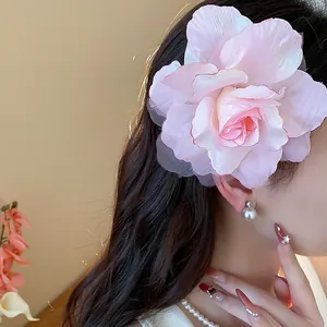 Nahaufnahme einer eleganten rosa Stoffblume-Haarklammer an einem Modell