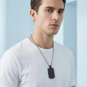 Male model wearing a minimalist black stainless steel dog tag pendant necklace on a chain.