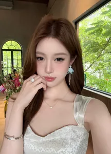 Asiatisches Model trägt elegante blaue Blüten-Ohrringe mit Perlen im französischen Stil