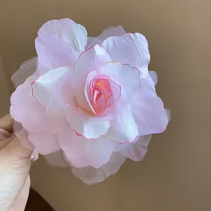 Detailansicht einer zarten rosa Stoff-Netz-Rosenblüte-Haarklammer mit weichen Blütenblättern.