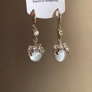 Elegant silver earrings with round cat-eye resin pendants and sparkling crystals