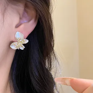 Detailed view of elegant white butterfly stud earrings with sparkling zircon accents