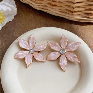 Detailed macro view of pink enamel flower stud earrings with central zircon stone