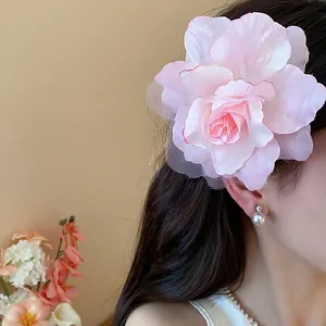Detailaufnahme einer zartrosa Haarklammer mit Stoffblume aus Mesh, getragen von einem Modell