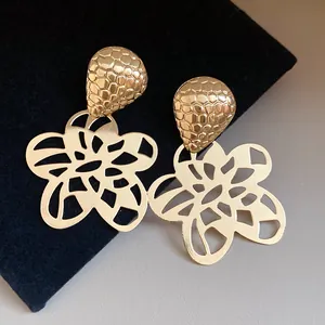 Detailansicht der goldenen hohlen Vintage-Ohrringe mit Blumenmuster und Wabenstruktur