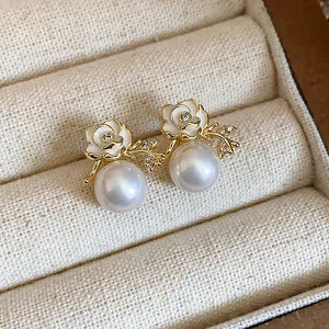 Dettaglio degli orecchini a lobo a fiore placcati oro 18k con zircone e perle bianche