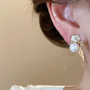Vista macro dettagliata di un elegante orecchino a lobo con fiore e perla placcato oro 18k