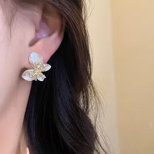 Detail shot of elegant butterfly-shaped earrings with pearls and sparkling zircons