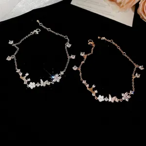 Elegant silver and rose gold zircon butterfly flower bracelets on black velvet.