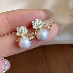 Dettaglio degli orecchini a rosa placcati oro 18k con perle bianche e zirconi