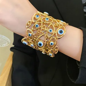 Splendido bracciale rigido dorato vintage traforato con motivi smaltati a forma di occhio