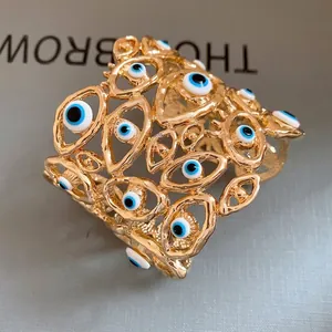 Elegante bracciale rigido vintage dorato traforato con molti ciondoli smaltati occhio greco