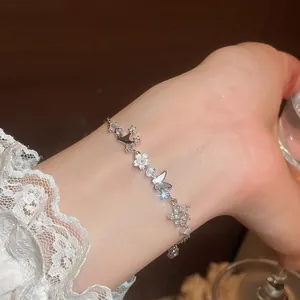 Detailed shot of a delicate butterfly and flower zircon bracelet on a wrist