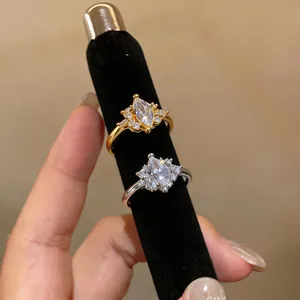 Detailed macro shot of two marquise-cut zircon rings in gold and silver finishes on a display.