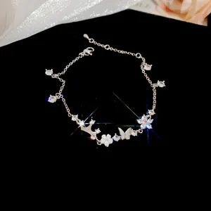 Close-up of zircon flower and butterfly charms on a silver bracelet for women