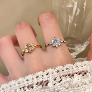 Close-up of gold and silver zircon rings with marquise-cut stones and lace sleeve detail