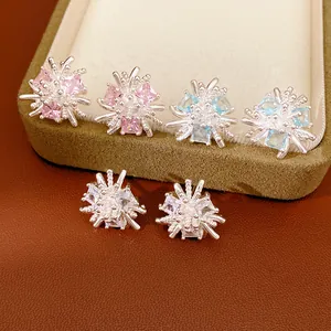Vue détaillée de boucles d'oreilles fleur en zircon étincelant : rose, bleu et clair.