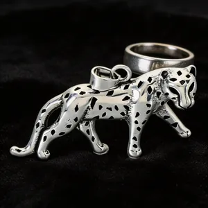 Close-up of vintage stainless steel leopard pendant with intricate black spotted details