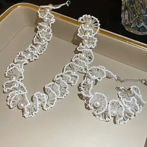 Detail of elegant French luxury beaded pearl necklace and bracelet set with scalloped design.