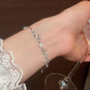 Elegant silver bracelet featuring butterfly and mother-of-pearl flower with zirconia