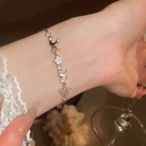 Macro shot of elegant rose gold bracelet with butterfly and flower charms on a lady's wrist