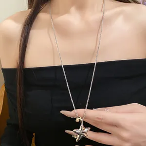 Primo piano di una collana in argento con ciondolo a stella e incisione 'Promise'